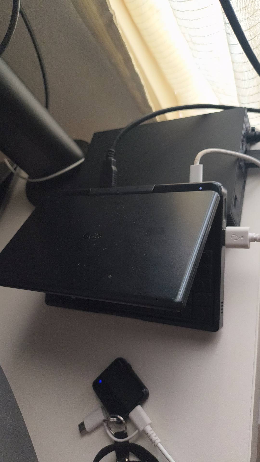 黒ノートPC上に外付けHDDとUSB接続されたLIFELOGレコーダー。手前にキーリング付き小型デバイスが充電中